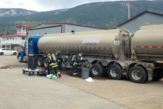 A fuel tanker spill, firefighters are cleaning the spill with absorbent granules and brooms.